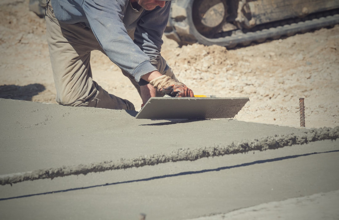 An image of a person working on a stained concrete service